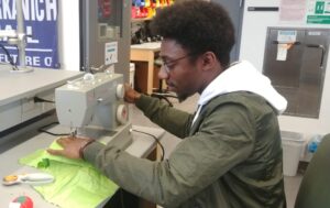 A student using the BE Labs' sewing machine for a project.
