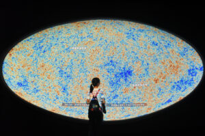 A child stops by an image of the cosmic microwave background at Shanghai Astronomy Museum in Shanghai, China on July 18, 2021. (Image: FeatureChina via AP Images) 