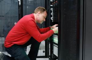 Greg Bowman kneels, working on a server.