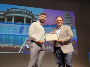 Paul Gehret and Riccardo Gottardi accept the International Society for Biofabrication New Investigator Award onstage at the international conference.